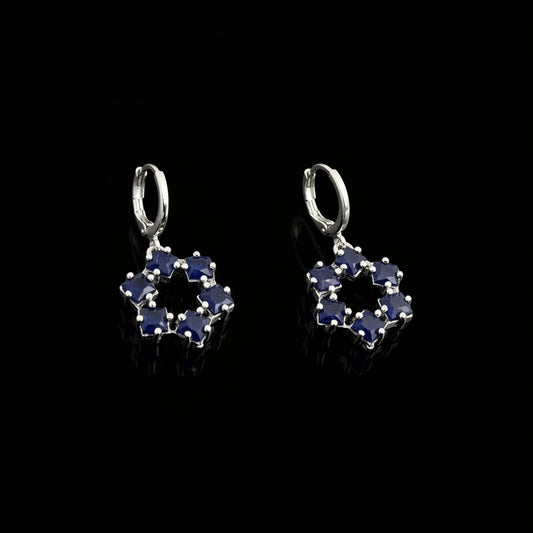 Pair of silver earrings with blue gemstones on a gray background, featuring the brand 'Saheli'.