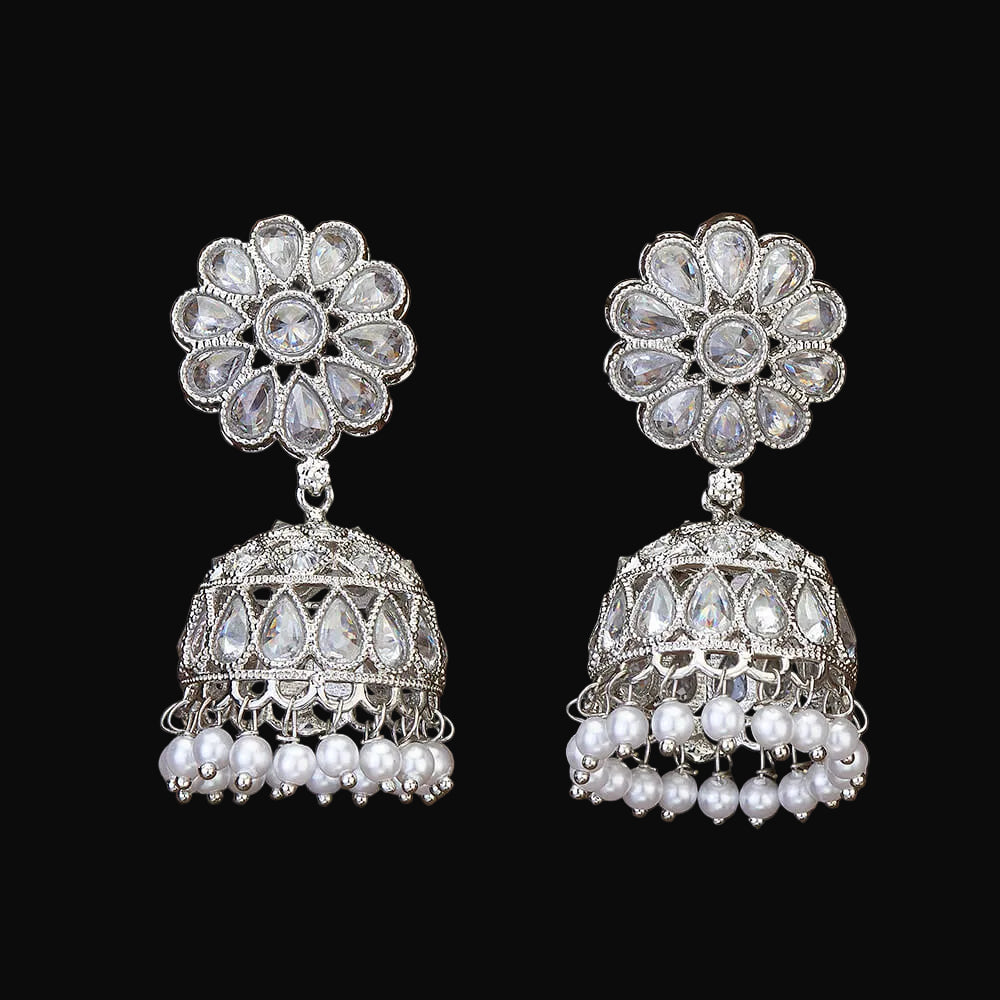 Pair of silver and pearl earrings on a wooden surface