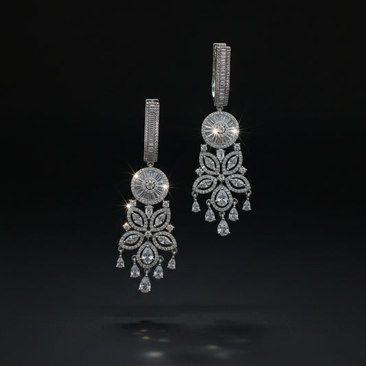 Pair of silver chandelier earrings on a dark background