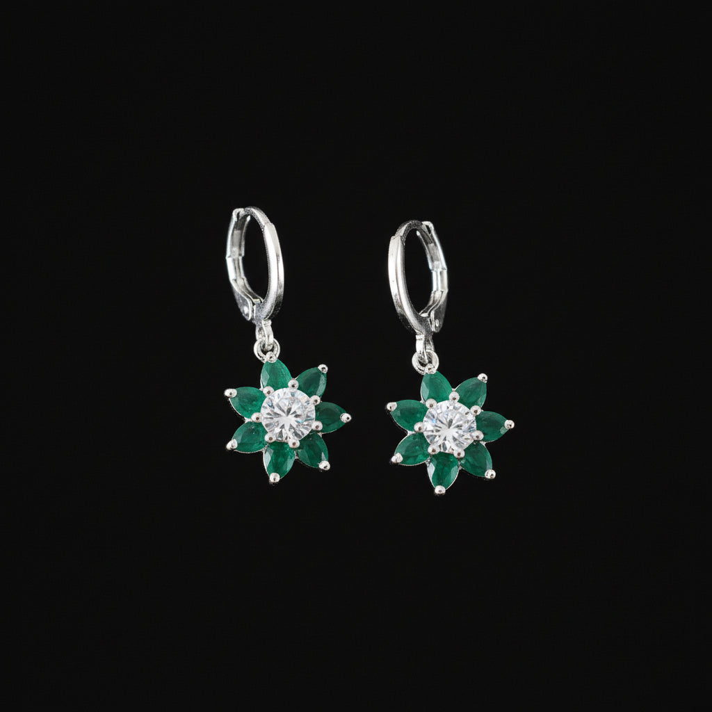 Pair of earrings with green gemstones on a dark background