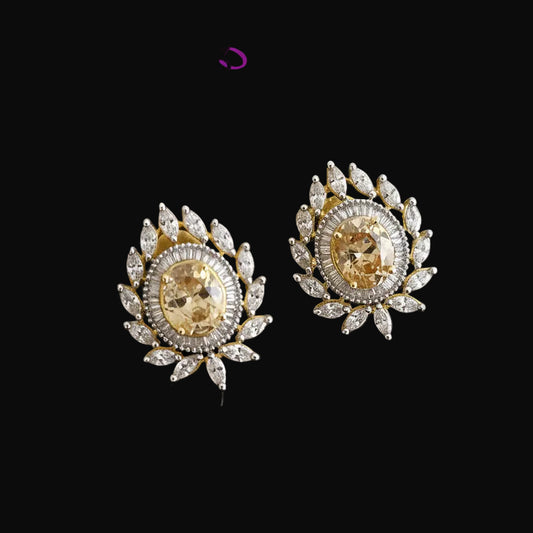 Gold and diamond earrings on a dark background with 'Saheli' brand logo.