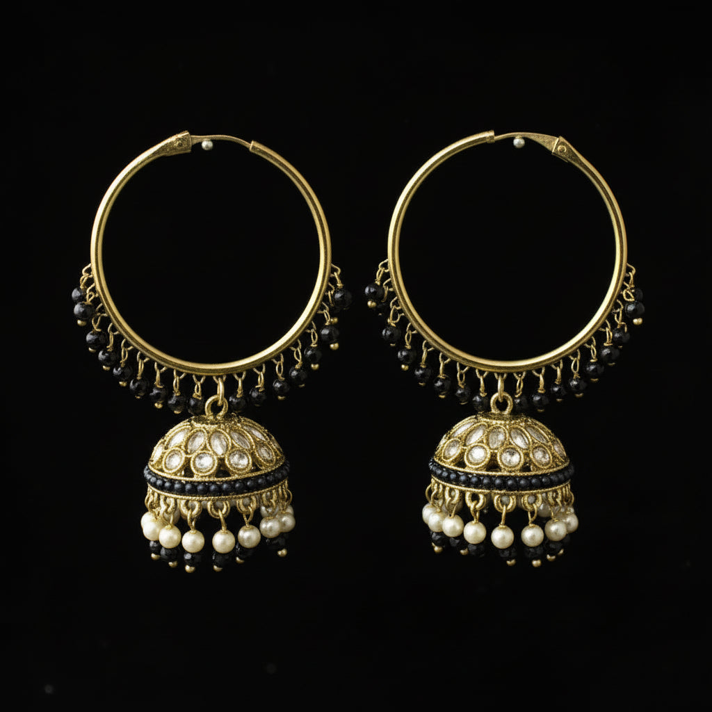 Pair of gold hoop earrings with pearl drops on a black background