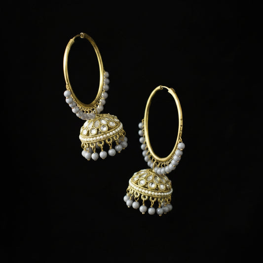 Gold hoop earrings with pearl drops on a black background