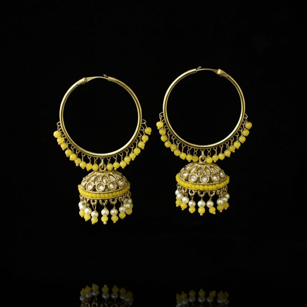 Gold hoop earrings with yellow beads and pearl-like elements on a black background