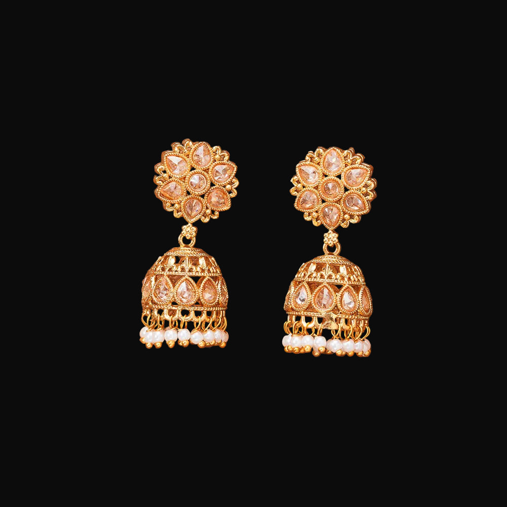 Gold earrings with floral design on a brown background