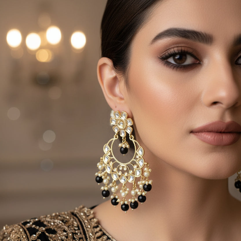 Ornate earrings with black beads on a dark background