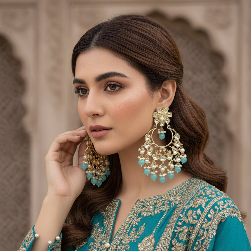 Pair of ornate earrings with turquoise stones on a dark background
