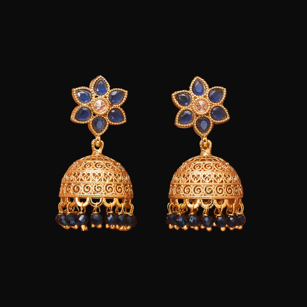 Gold and blue floral earrings on a brown background