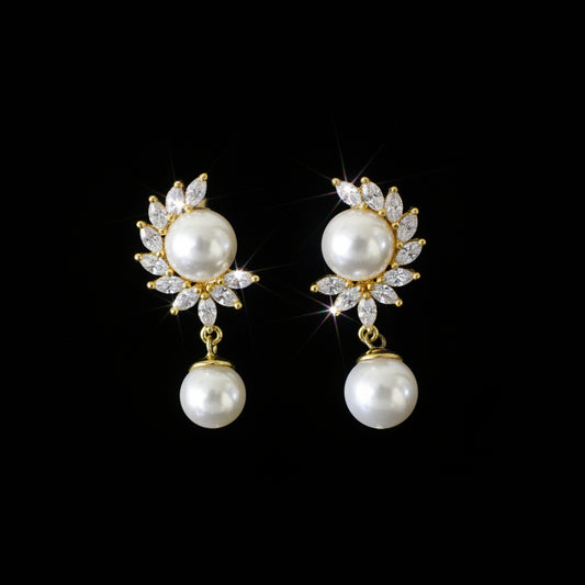 Pearl earrings on a black stand with 'SAHELI' branding on a gray background
