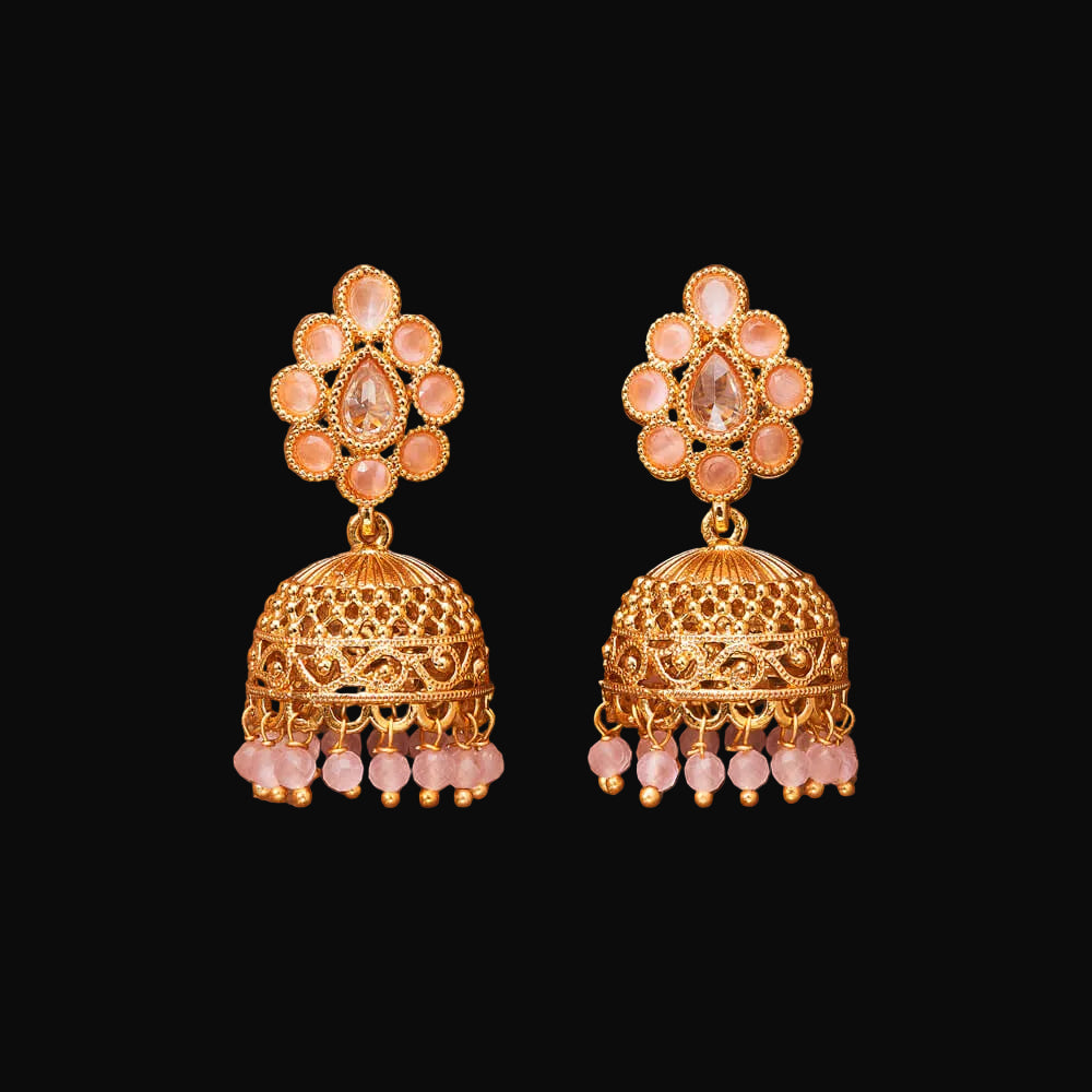 Gold and pink earrings on a brown background