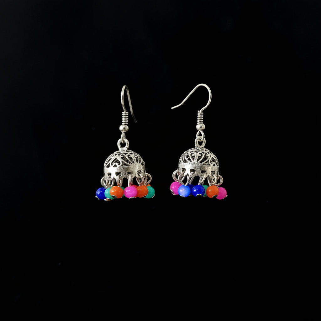 Silver earrings with colorful beads on a gray stand, branded 'Saheli'.