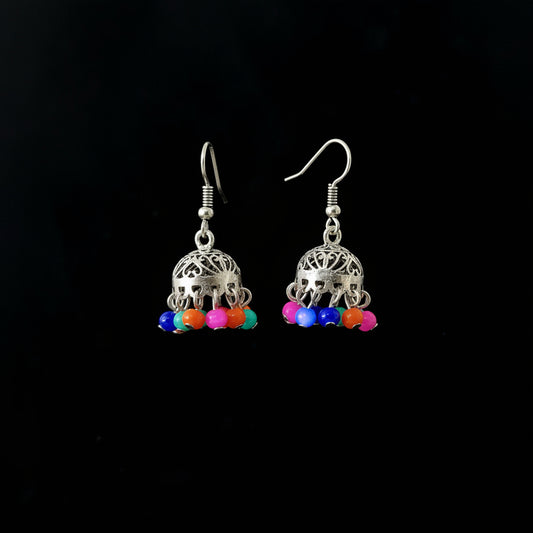 Silver earrings with colorful beads on a gray stand, branded 'Saheli'.