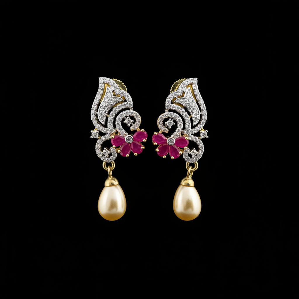 A pair of gold and silver-toned drop earrings with pink floral accents and teardrop pearls, displayed on a black stand against a gray background with the SAHELI brand logo above.