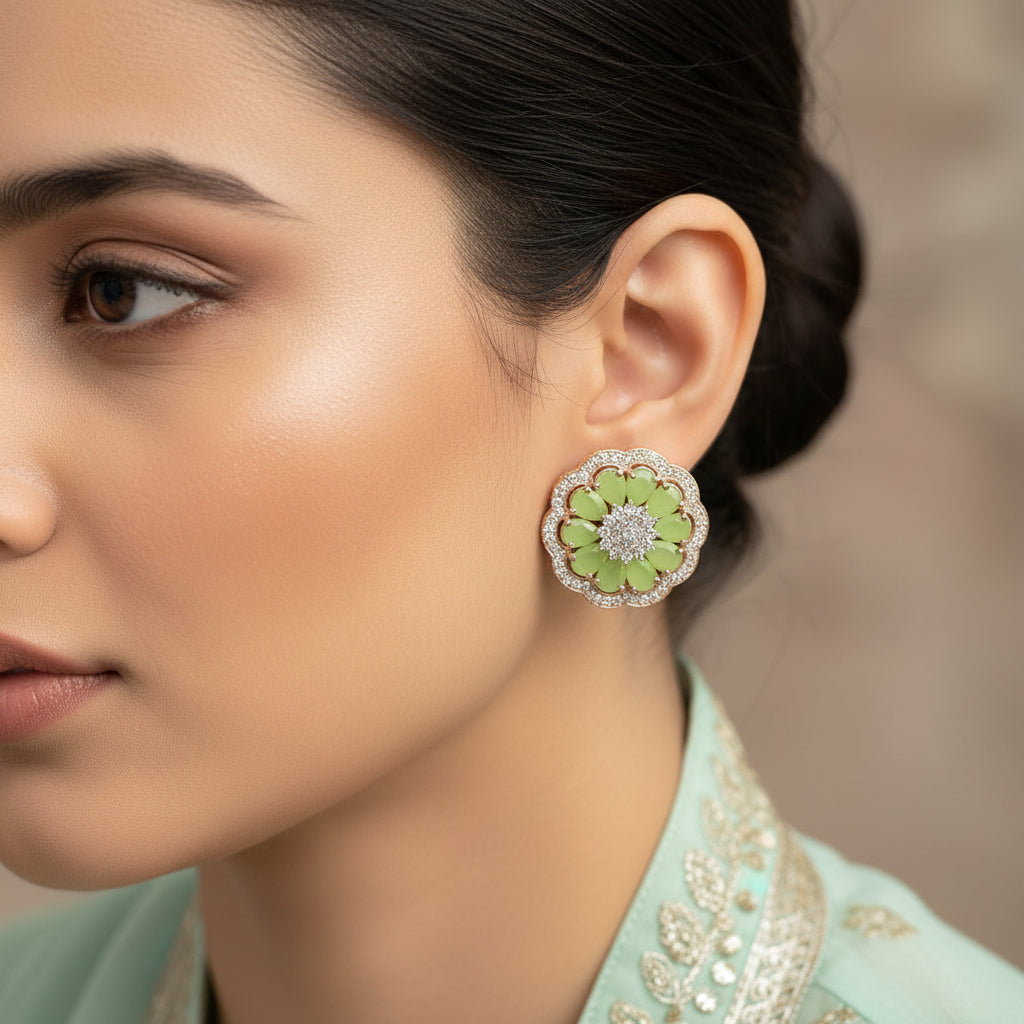 Pair of green floral earrings with diamond center on a dark background, branded 'SAHELI'.