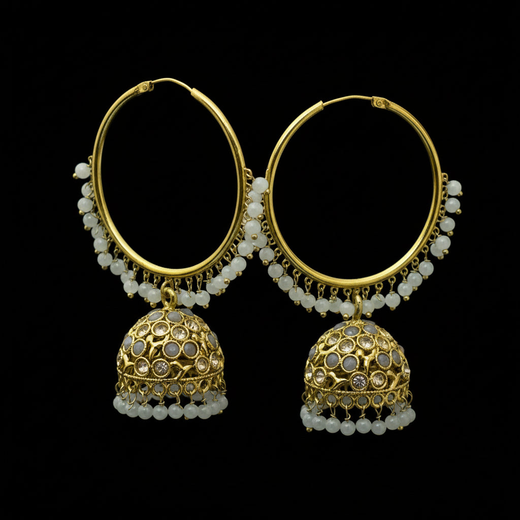Gold and pearl earrings on a dark stand with 'SAHELI' branding.