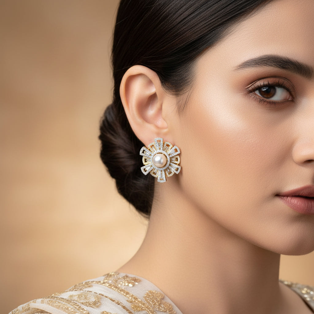 Pair of gold and pearl earrings on a dark background