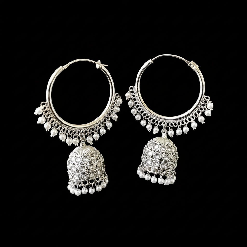 Pair of silver hoop earrings with jhumkas on a black background, branded 'Saheli'.