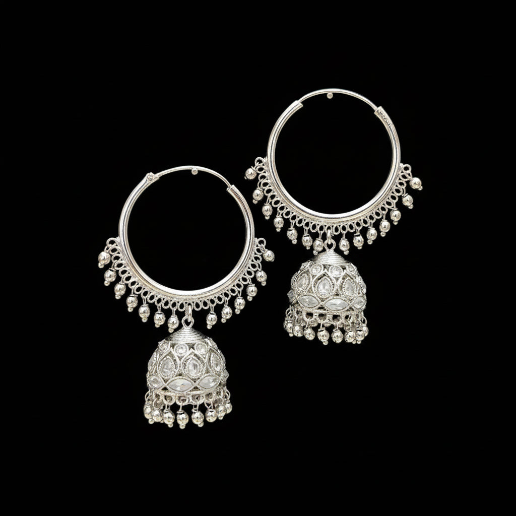 Silver hoop earrings with jhumkas on black stands against a gray background, branded 'Saheli'.