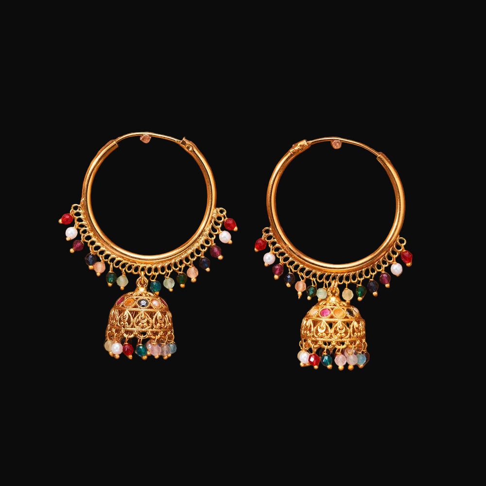 Gold hoop earrings with colorful beads on a brown background