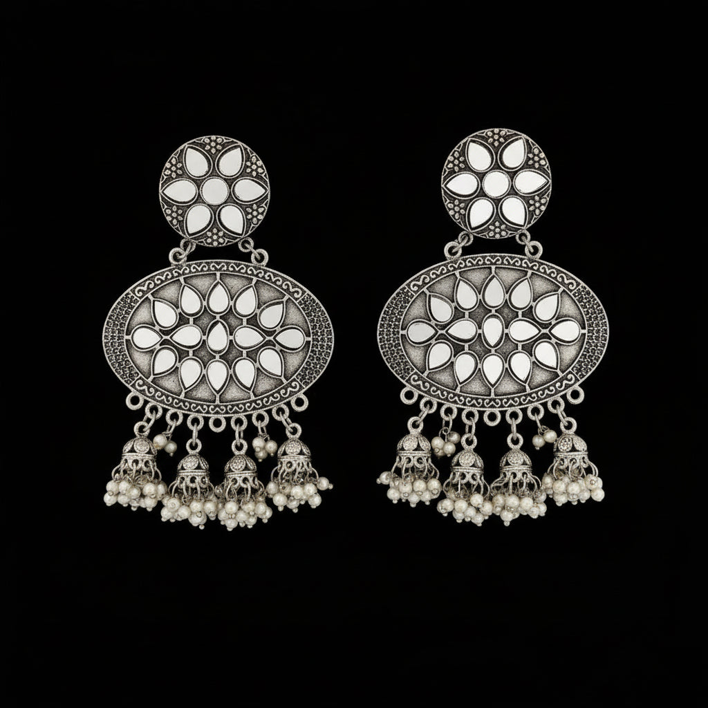 Ornate silver earrings with pearl-like stones on a dark background, featuring the brand 'Sahell'.