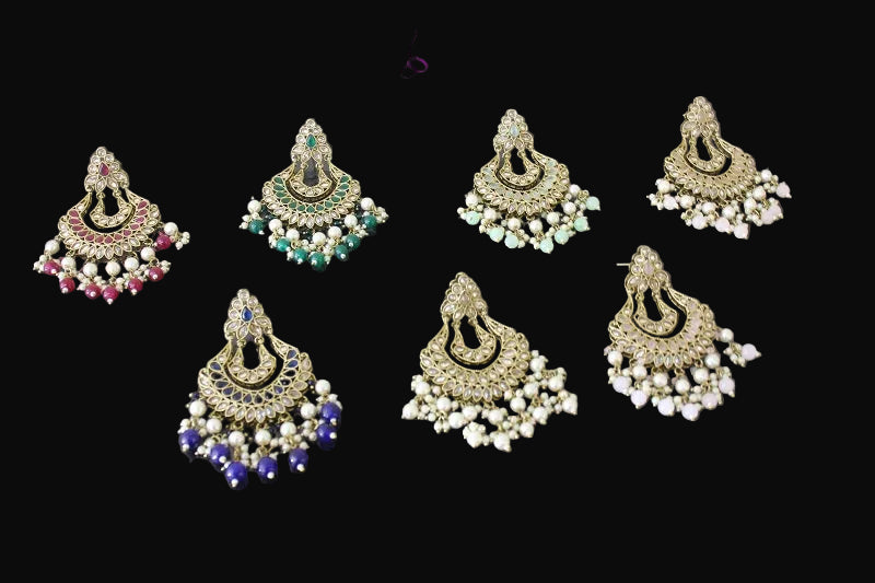 Set of ornate earrings with gemstones on a dark background, branded 'Sahelli'.