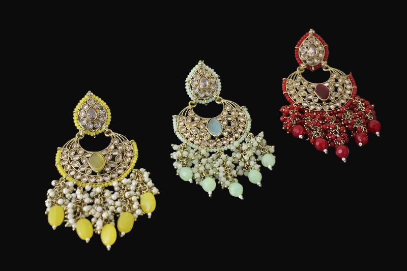 Three pairs of ornate earrings with different color schemes on a gray background, branded 'Saheli'.