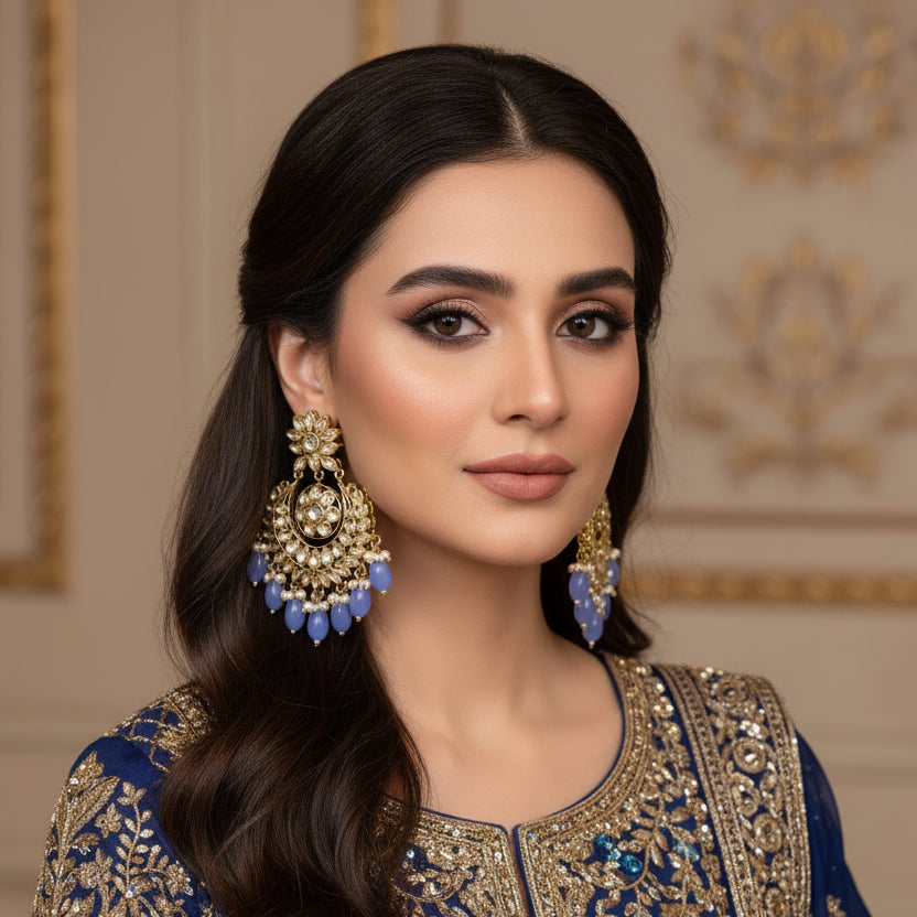Pair of ornate earrings with blue stones on a dark background