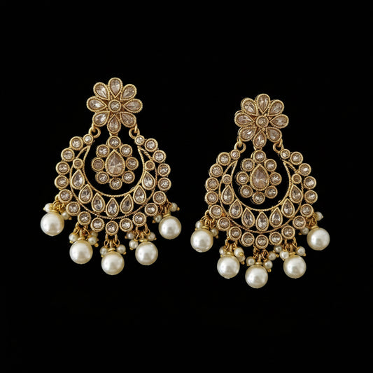 Gold and pearl earrings with 'SAHELI' branding on a dark background
