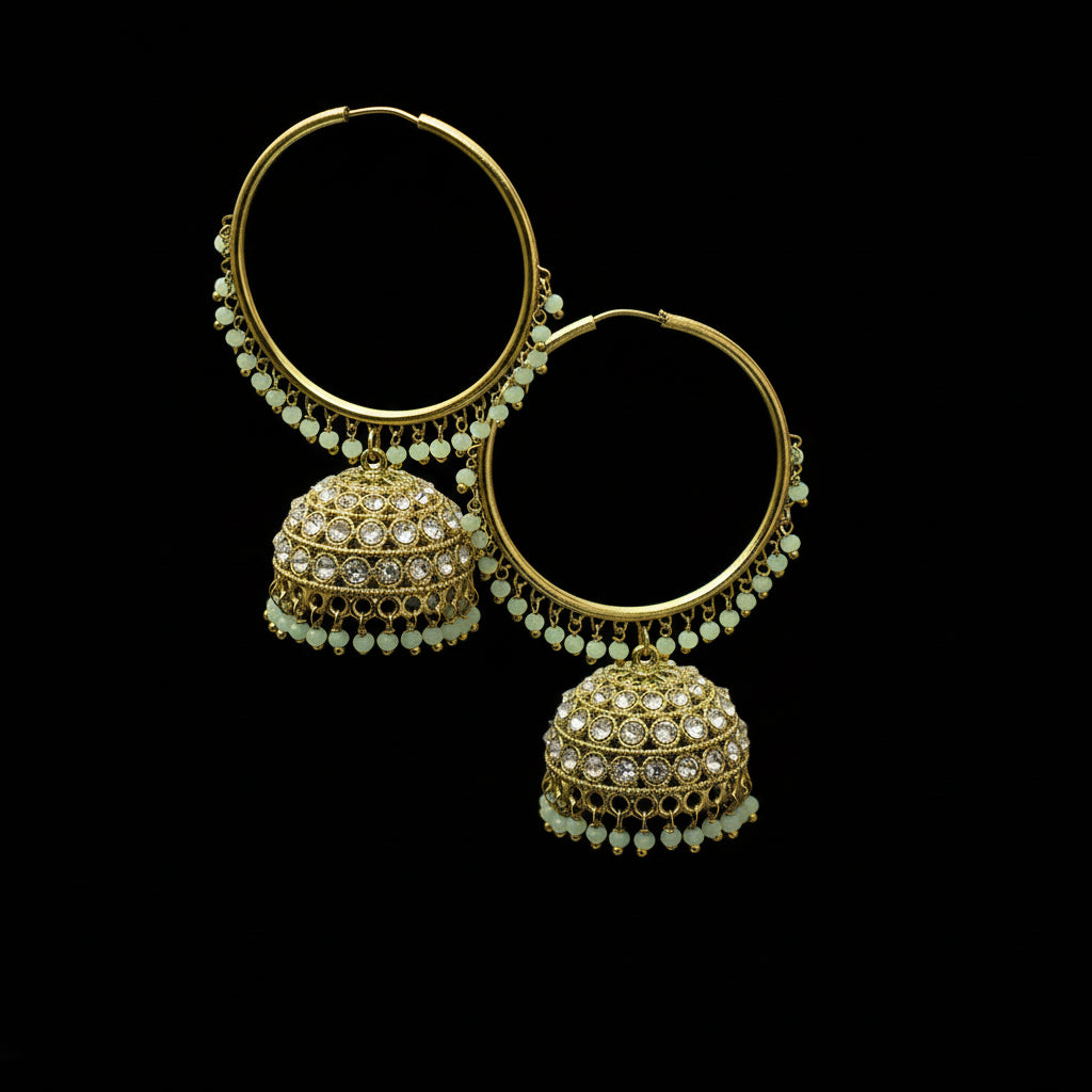 Gold hoop earrings with green gemstones on a black stand against a gray background, branded 'Saheli'.