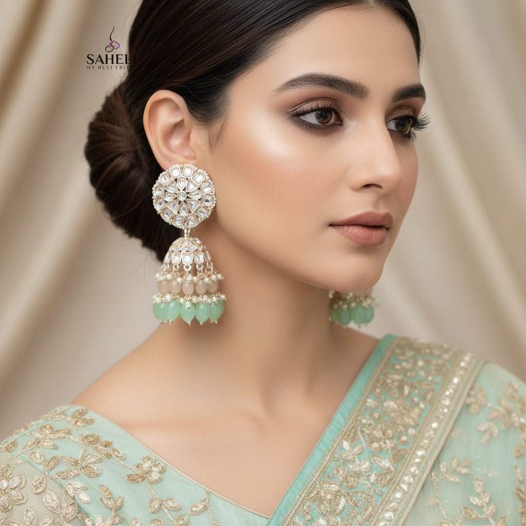 Ornate earrings with green accents on a dark background