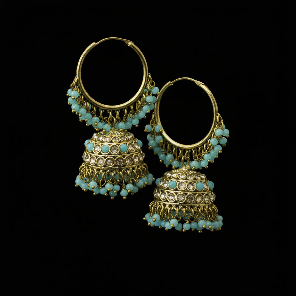 Gold hoop earrings with turquoise beads on a black stand against a gray background