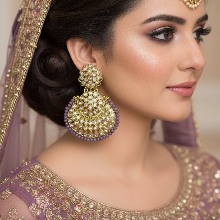 Gold and purple earrings with 'SAHELI' branding on a gray background