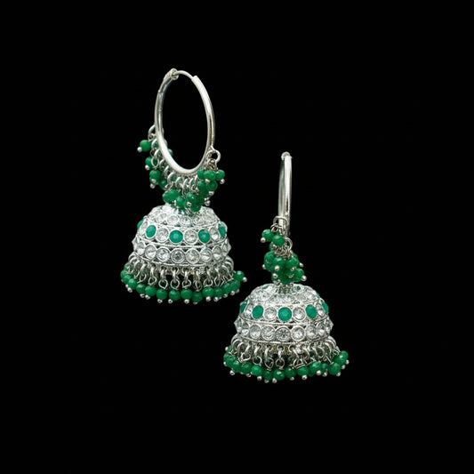 Green and silver beaded earrings on a black stand with a gray background