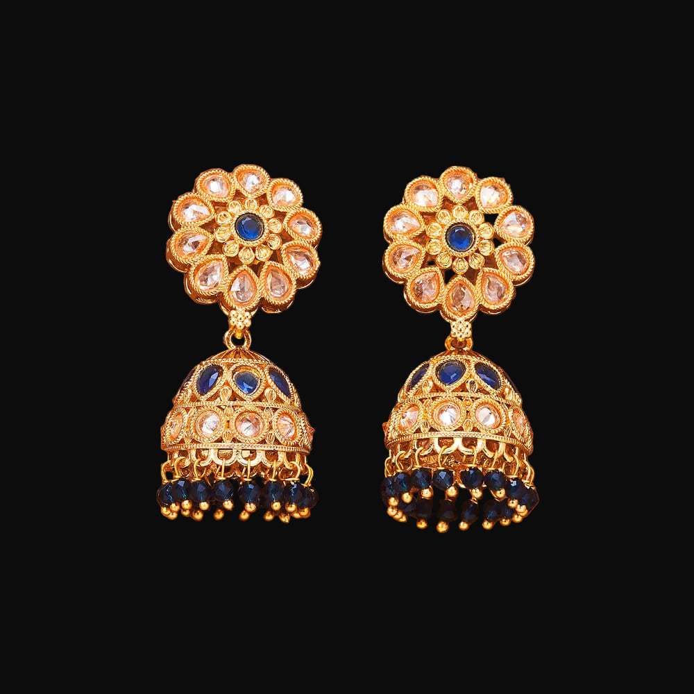Pair of gold and blue earrings on a brown background
