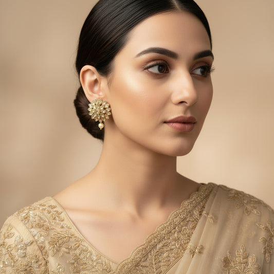 Pair of gold and pearl earrings on a dark gray background