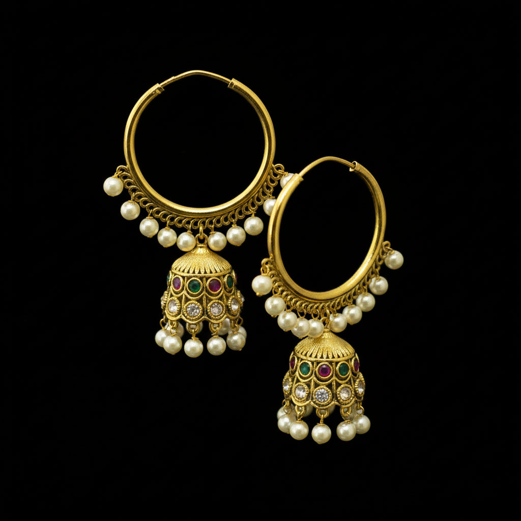 Gold earrings with pearl and gemstone details on a black stand, branded 'Saheli'.