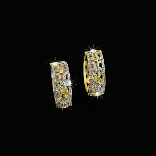 Gold hoop earrings with intricate designs on a dark background, featuring the brand 'Saheili'.