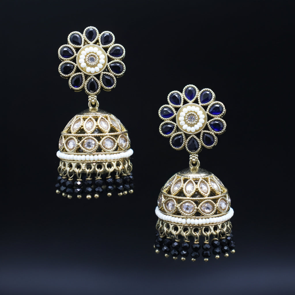 Pair of gold and black floral earrings on a dark background