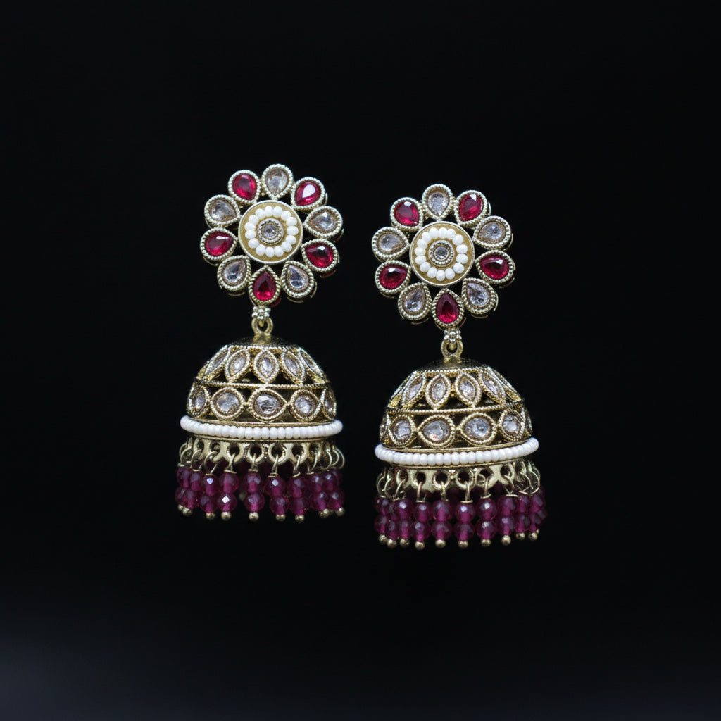 Pair of ornate earrings with gemstones on a black background