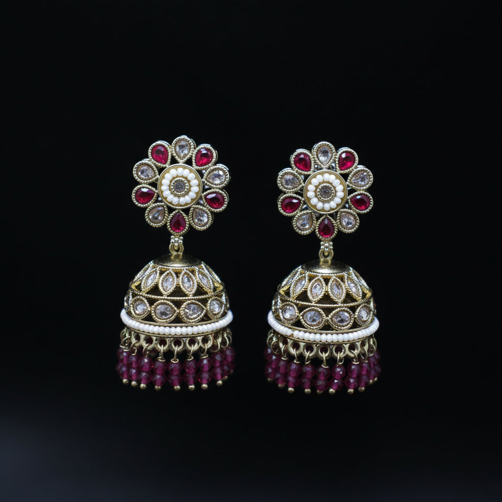 Pair of ornate earrings with gemstones on a black background