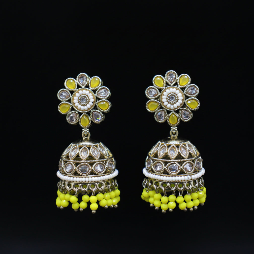 Pair of ornate earrings with floral top and beaded bottom on a black background