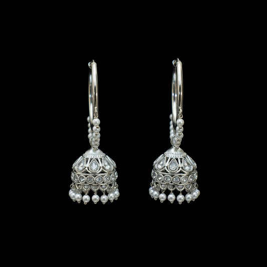 Silver earrings with pearl-like beads on a dark background