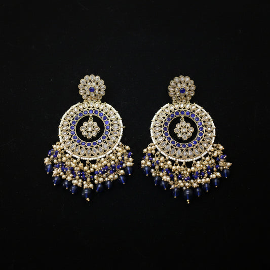 Pair of ornate earrings with blue and gold details on a gray background
