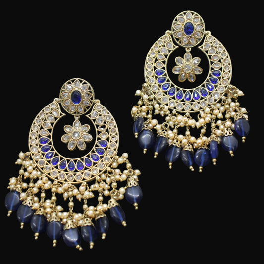 Ornate gold and blue earrings on a dark gray background