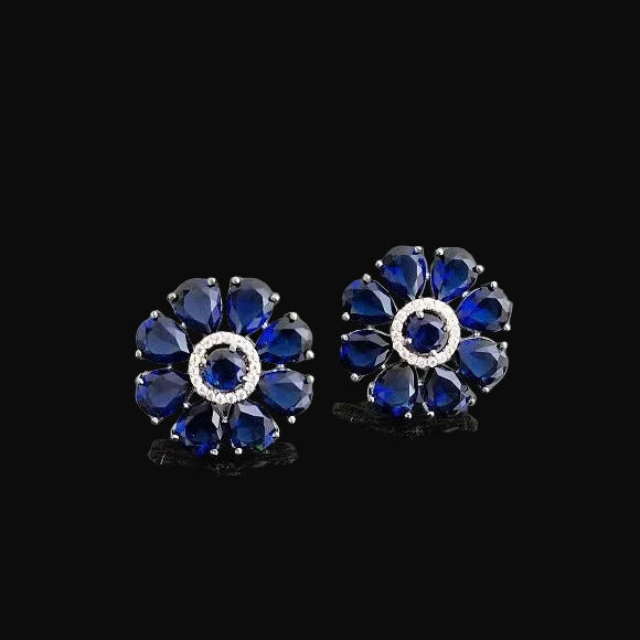 Pair of blue gemstone earrings on a gray background