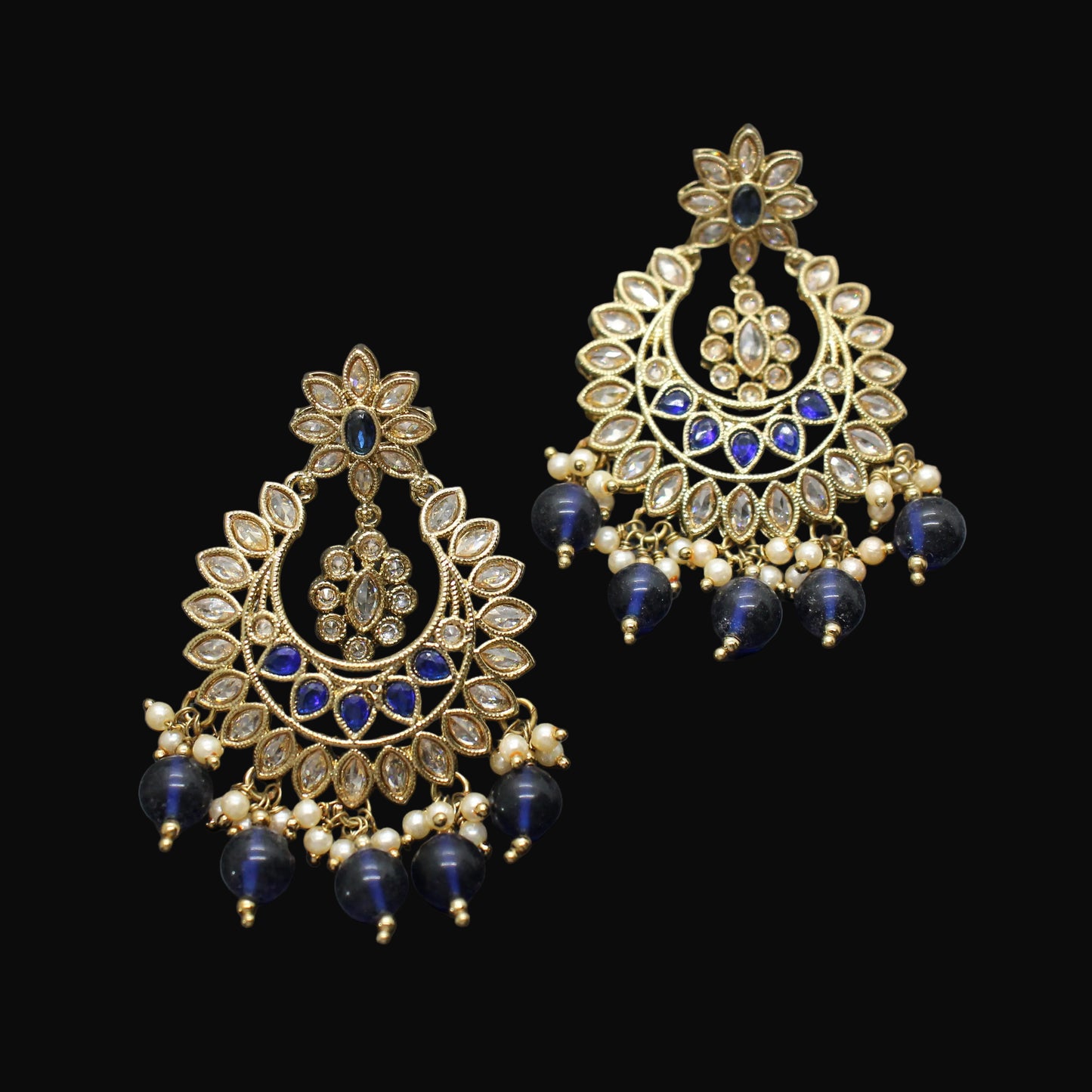Pair of gold and blue earrings on a dark gray background