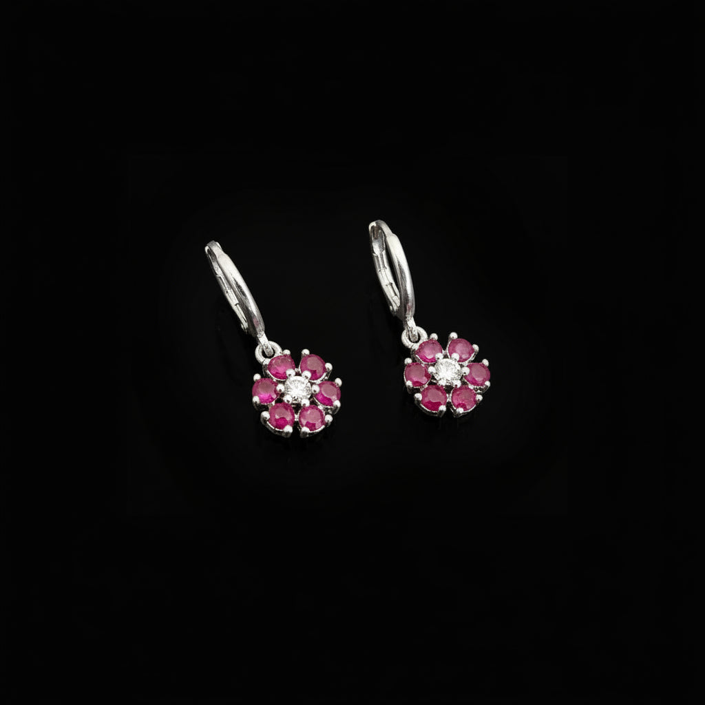 Silver earrings with pink gemstones on a gray background, featuring the brand 'SAHELI'.