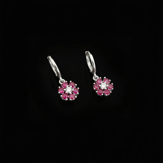 Silver earrings with pink gemstones on a gray background, featuring the brand 'SAHELI'.