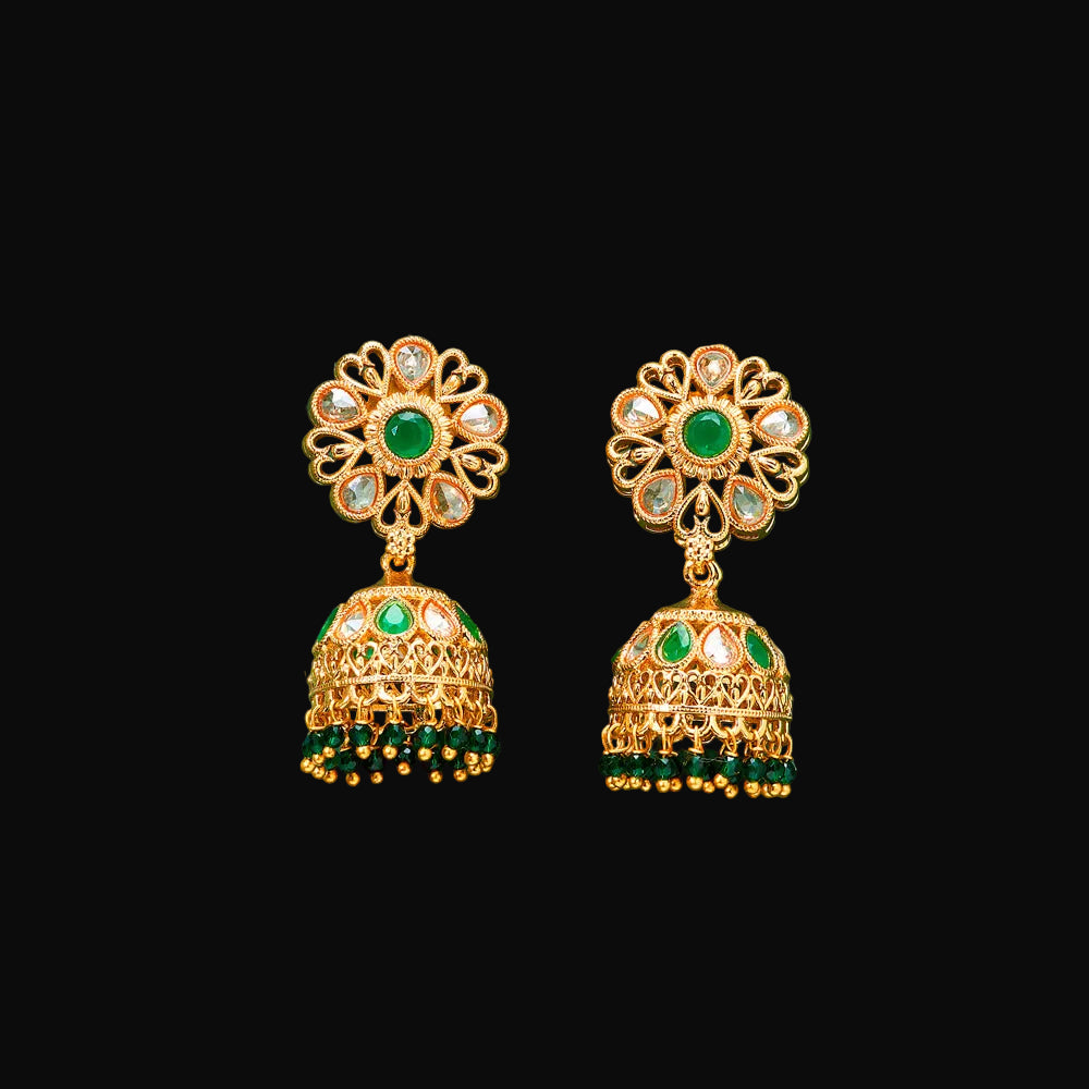 Gold earrings with green gemstones on a teal background