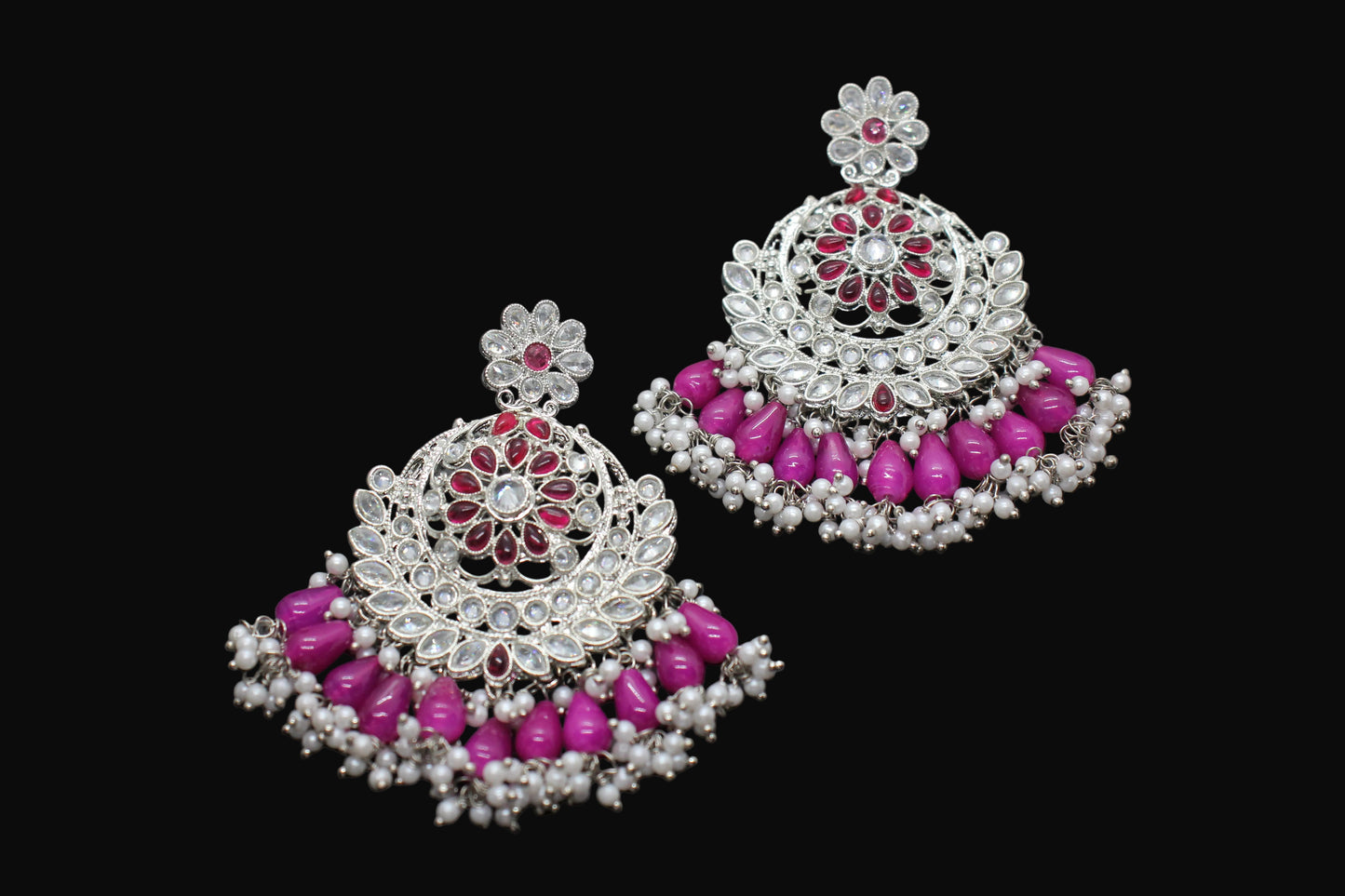 Pair of silver and pink beaded earrings on a dark background